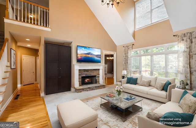203 Crescent Moon Way, Canton, GA 30114 - living room with a high ceiling, a chandelier, light wood finished floors, a stone fireplace, and stairway