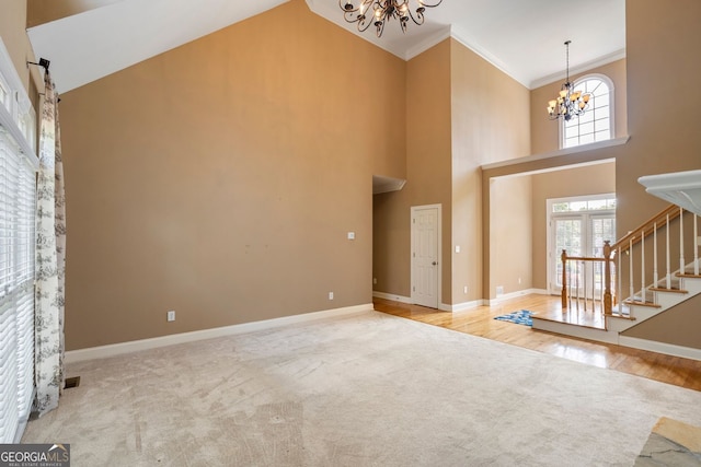 203 Crescent Moon Way, Canton, GA 30114 - carpeted entryway featuring a chandelier, stairway, crown molding, a towering ceiling, and baseboards