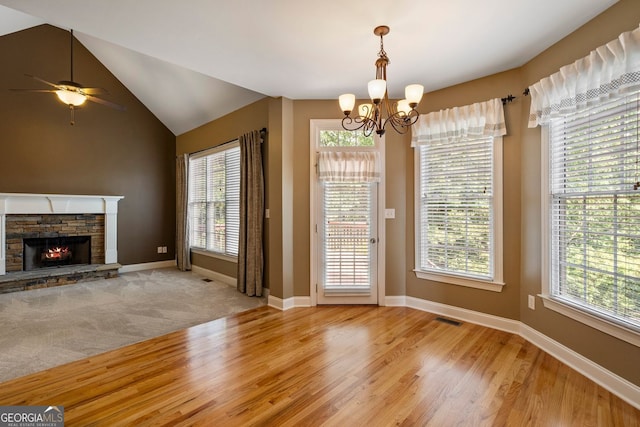203 Crescent Moon Way, Canton, GA 30114 - unfurnished dining area featuring a chandelier, healthy amount of natural light, wood finished floors, a stone fireplace, and lofted ceiling