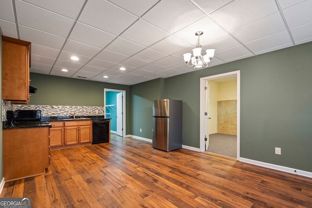 203 Crescent Moon Way, Canton, GA 30114 - kitchen with black appliances, dark countertops, brown cabinetry, dark wood-style floors, and a drop ceiling