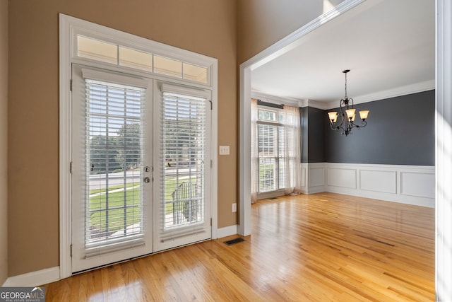 203 Crescent Moon Way, Canton, GA 30114 - doorway to outside with a chandelier, french doors, wood finished floors, ornamental molding, and a wainscoted wall