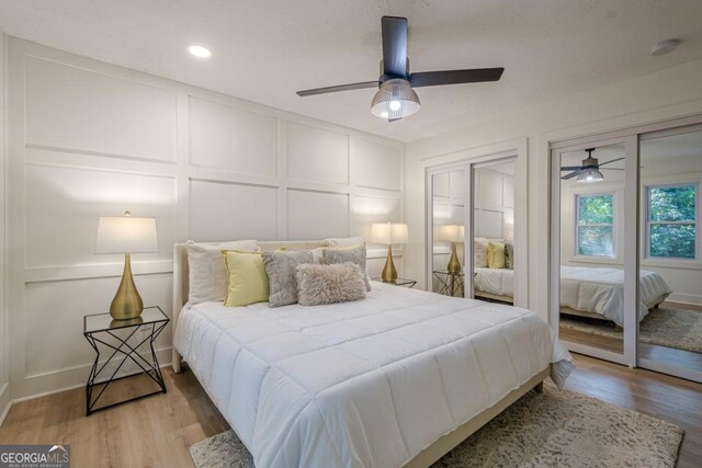 2825 Shea Way SW, Marietta, GA 30060 - bedroom with a decorative wall, light wood-type flooring, a ceiling fan, two closets, and recessed lighting