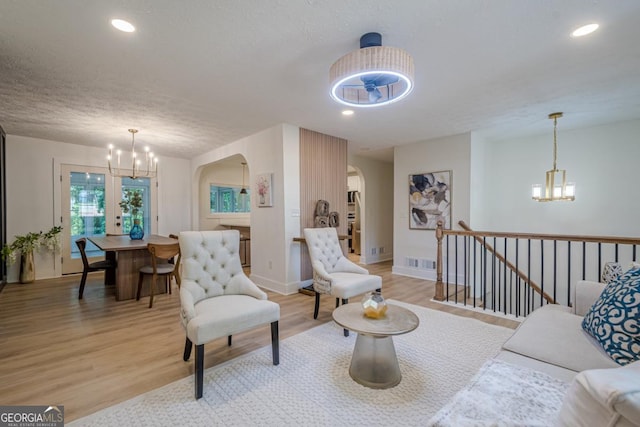 2825 Shea Way SW, Marietta, GA 30060 - living area with a chandelier, arched walkways, light wood-style floors, recessed lighting, and a textured ceiling