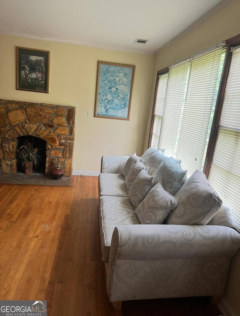 5094 Covington Hwy, Decatur, GA 30035 - living area with hardwood / wood-style floors, a stone fireplace, and ornamental molding