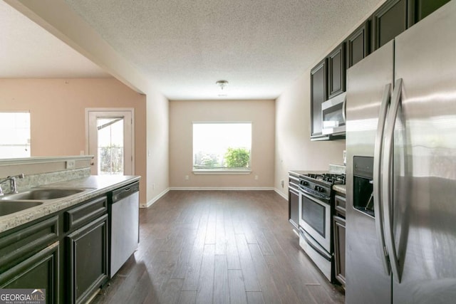 171 Stillwood Dr, Newnan, GA 30265 - kitchen featuring stainless steel appliances, dark wood finished floors, light countertops, and a textured ceiling