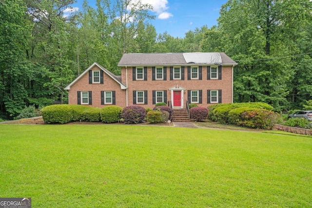 1777 E Gate Trl, Stone Mountain, GA 30087 - colonial-style house with a front yard and brick siding