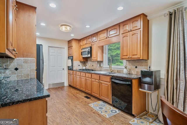 1777 E Gate Trl, Stone Mountain, GA 30087 - kitchen with black appliances, light wood-type flooring, backsplash, recessed lighting, and dark stone countertops