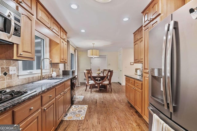 1777 E Gate Trl, Stone Mountain, GA 30087 - kitchen featuring stainless steel appliances, a sink, wood finished floors, tasteful backsplash, and dark stone counters