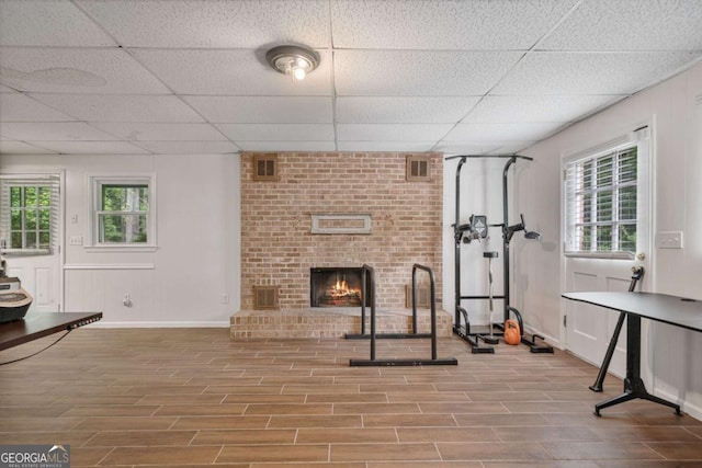 1777 E Gate Trl, Stone Mountain, GA 30087 - exercise area featuring wood finished floors, a drop ceiling, a fireplace, and baseboards