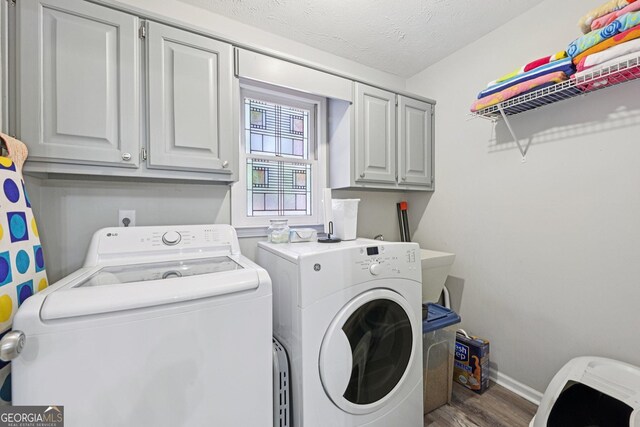 130 Emerald Dr, Mcdonough, GA 30253 - laundry room featuring washer and clothes dryer, cabinet space, wood finished floors, and a textured ceiling