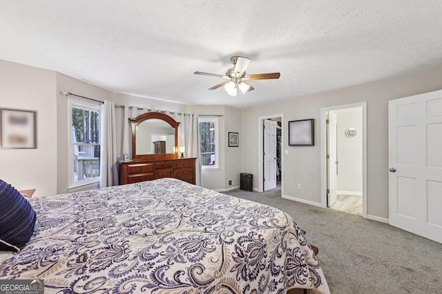 130 Emerald Dr, Mcdonough, GA 30253 - bedroom featuring multiple windows, carpet floors, a walk in closet, ceiling fan, and a textured ceiling