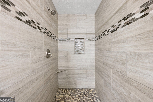 130 Emerald Dr, Mcdonough, GA 30253 - bathroom featuring tiled shower and a textured ceiling