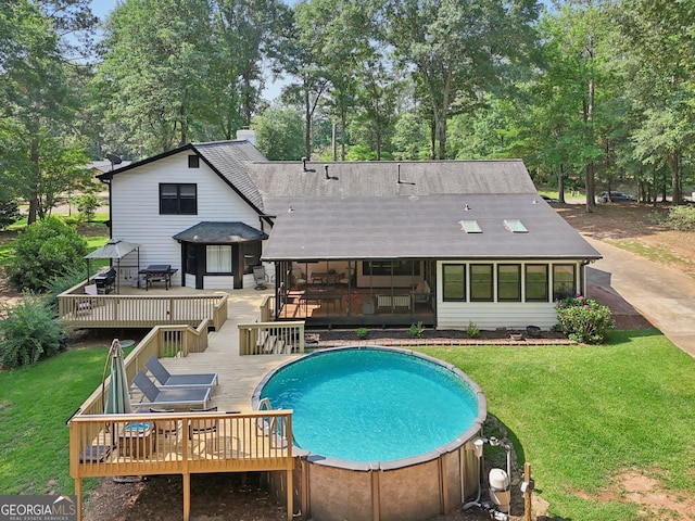 130 Emerald Dr, Mcdonough, GA 30253 - back of property with a deck, a yard, view of wooded area, and an outdoor pool
