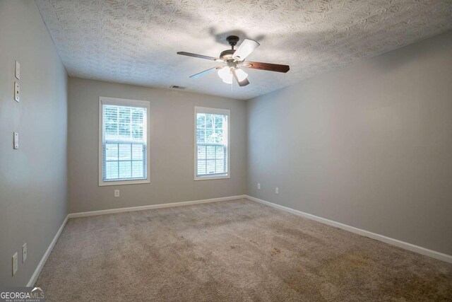 2482 Brittany Park Ln, Ellenwood, GA 30294 - carpeted empty room with a textured ceiling, a ceiling fan, and baseboards