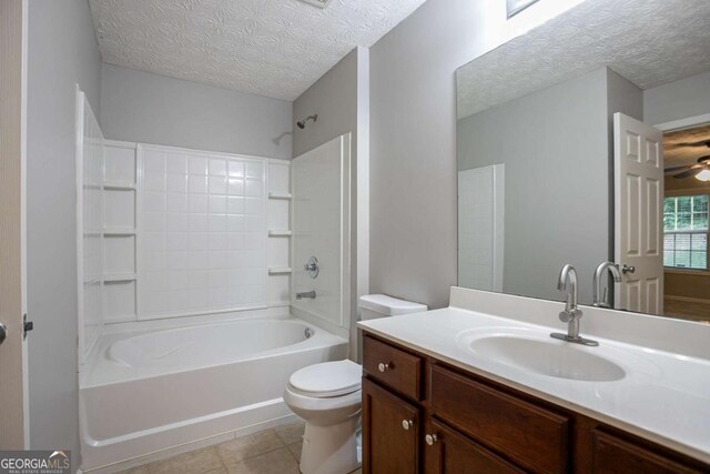 2482 Brittany Park Ln, Ellenwood, GA 30294 - bathroom featuring a textured ceiling, tile patterned flooring, toilet, tub / shower combination, and vanity