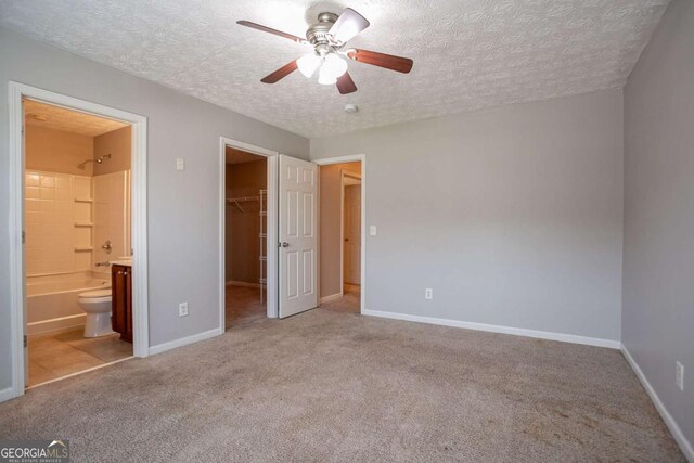 2482 Brittany Park Ln, Ellenwood, GA 30294 - unfurnished bedroom with a textured ceiling, lofted ceiling, carpet, and baseboards