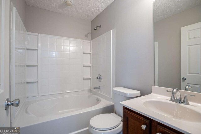 2482 Brittany Park Ln, Ellenwood, GA 30294 - bathroom with a textured ceiling, toilet, vanity, and bathing tub / shower combination