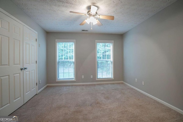 2482 Brittany Park Ln, Ellenwood, GA 30294 - unfurnished bedroom featuring baseboards, carpet, a textured ceiling, and a ceiling fan