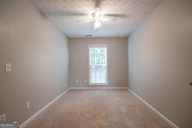 2482 Brittany Park Ln, Ellenwood, GA 30294 - unfurnished living room featuring a fireplace, ornate columns, light carpet, ceiling fan, and a textured ceiling
