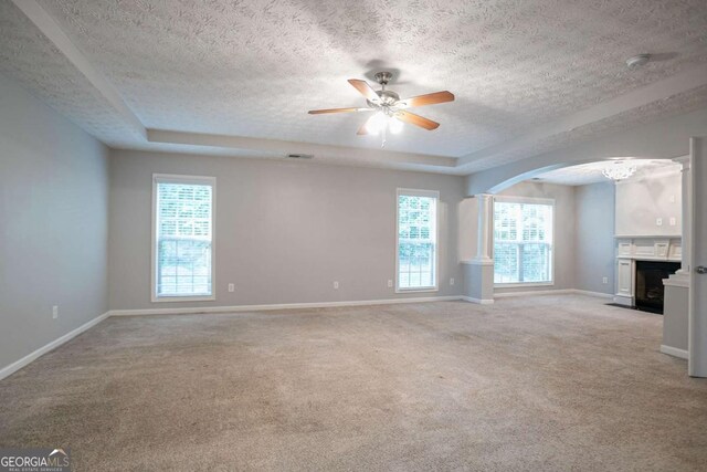 2482 Brittany Park Ln, Ellenwood, GA 30294 - unfurnished living room featuring a raised ceiling, carpet, a textured ceiling, ceiling fan, and baseboards