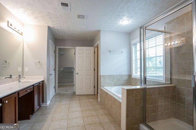 2482 Brittany Park Ln, Ellenwood, GA 30294 - full bathroom with tile patterned floors, a shower stall, vanity, a bath, and a textured ceiling