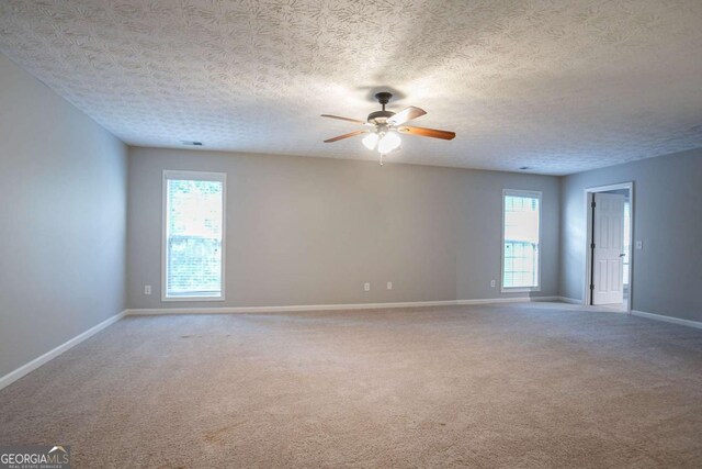 2482 Brittany Park Ln, Ellenwood, GA 30294 - unfurnished room with carpet flooring, ceiling fan, healthy amount of natural light, baseboards, and a textured ceiling