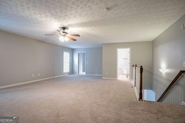 2482 Brittany Park Ln, Ellenwood, GA 30294 - empty room featuring light carpet, baseboards, ceiling fan, and a textured ceiling