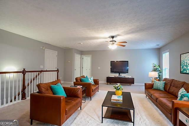 2482 Brittany Park Ln, Ellenwood, GA 30294 - living area with a ceiling fan, light colored carpet, baseboards, and a textured ceiling