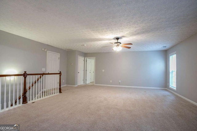 2482 Brittany Park Ln, Ellenwood, GA 30294 - unfurnished room with light carpet, ceiling fan, baseboards, and a textured ceiling