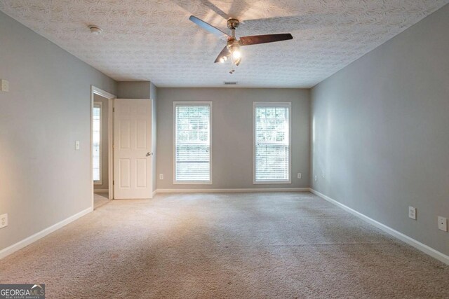 2482 Brittany Park Ln, Ellenwood, GA 30294 - carpeted empty room with a ceiling fan, baseboards, and a textured ceiling