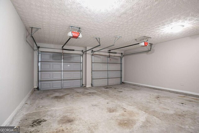 2482 Brittany Park Ln, Ellenwood, GA 30294 - garage featuring a garage door opener and baseboards