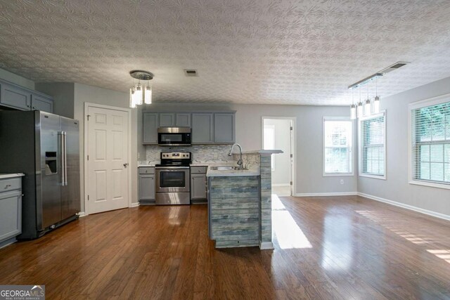 2482 Brittany Park Ln, Ellenwood, GA 30294 - kitchen with stainless steel appliances, gray cabinetry, a sink, light countertops, and a peninsula