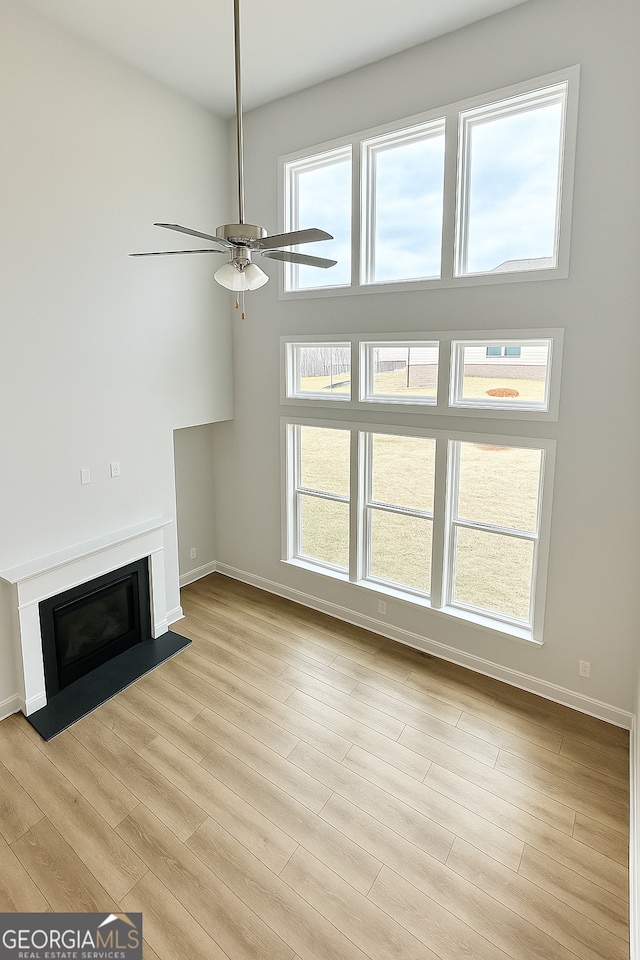 3468 Jasmine Way SW, South Fulton, GA 30331 - unfurnished living room with ceiling fan, a fireplace with flush hearth, baseboards, and light wood finished floors