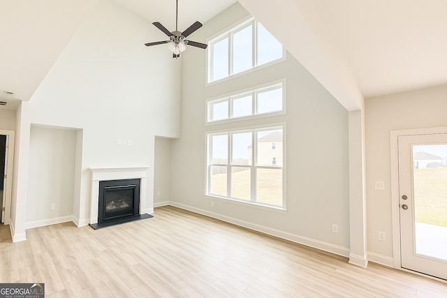 3468 Jasmine Way SW, South Fulton, GA 30331 - unfurnished living room featuring high vaulted ceiling, a glass covered fireplace, light wood-type flooring, a ceiling fan, and baseboards