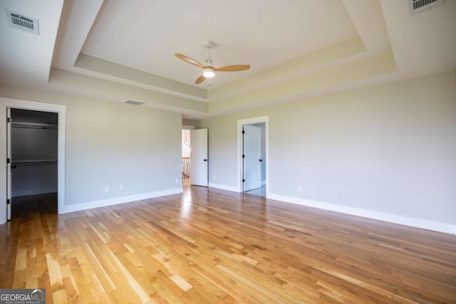 982 Wildberry Ct, Jefferson, GA 30549 - unfurnished bedroom featuring a tray ceiling, light wood-type flooring, baseboards, and a spacious closet