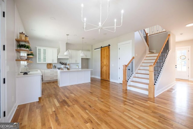 982 Wildberry Ct, Jefferson, GA 30549 - kitchen with a barn door, premium range hood, open shelves, a chandelier, and white cabinets