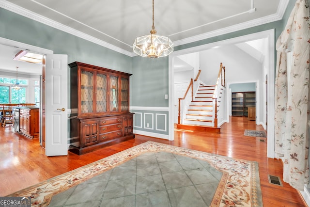 242 Pristine Cv, Hartwell, GA 30643 - entryway featuring a chandelier, stairs, wood finished floors, ornamental molding, and a wainscoted wall