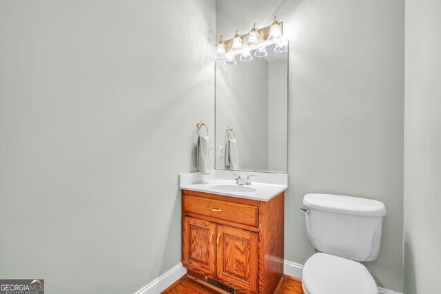 242 Pristine Cv, Hartwell, GA 30643 - half bathroom with toilet, vanity, baseboards, and wood finished floors