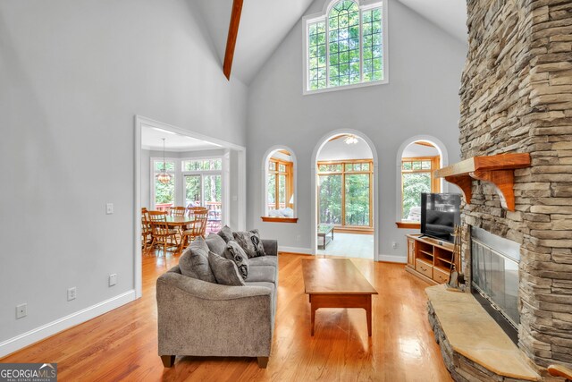 242 Pristine Cv, Hartwell, GA 30643 - living area with a fireplace, light wood-type flooring, healthy amount of natural light, baseboards, and high vaulted ceiling