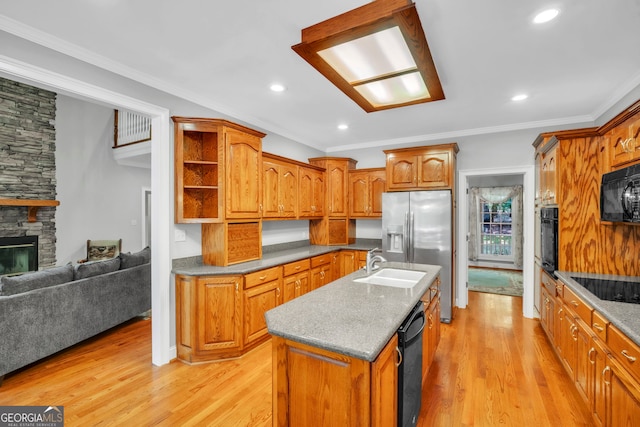 242 Pristine Cv, Hartwell, GA 30643 - kitchen with light wood-style floors, a kitchen island with sink, black appliances, brown cabinetry, and ornamental molding