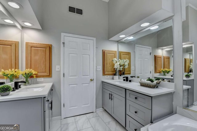 4901 Briarleigh Chase SW, Mableton, GA 30126 - full bath featuring two vanities, marble finish flooring, recessed lighting, a bathtub, and a high ceiling