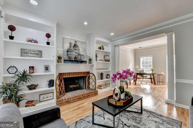 4901 Briarleigh Chase SW, Mableton, GA 30126 - living area with ornamental molding, built in shelves, wood finished floors, a fireplace, and ornate columns