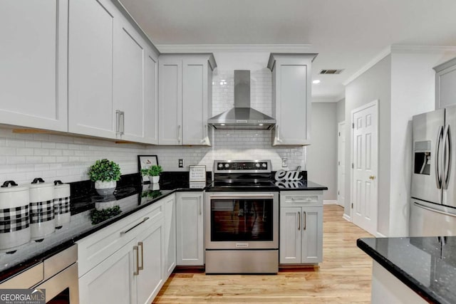 4901 Briarleigh Chase SW, Mableton, GA 30126 - kitchen featuring appliances with stainless steel finishes, wall chimney range hood, dark stone counters, gray cabinetry, and crown molding