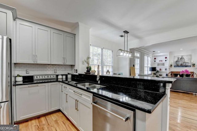 4901 Briarleigh Chase SW, Mableton, GA 30126 - kitchen with stainless steel appliances, a peninsula, open floor plan, light wood finished floors, and decorative backsplash