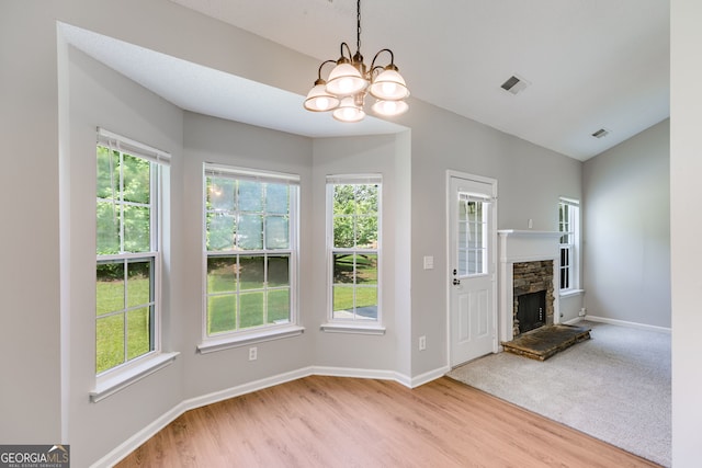305 Overland Trl, Temple, GA 30179 - unfurnished living room with healthy amount of natural light, wood finished floors, baseboards, and a chandelier