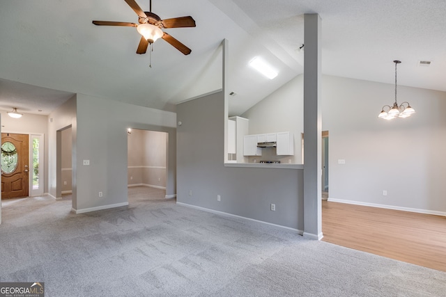 305 Overland Trl, Temple, GA 30179 - unfurnished living room with high vaulted ceiling, a ceiling fan, light colored carpet, baseboards, and a chandelier