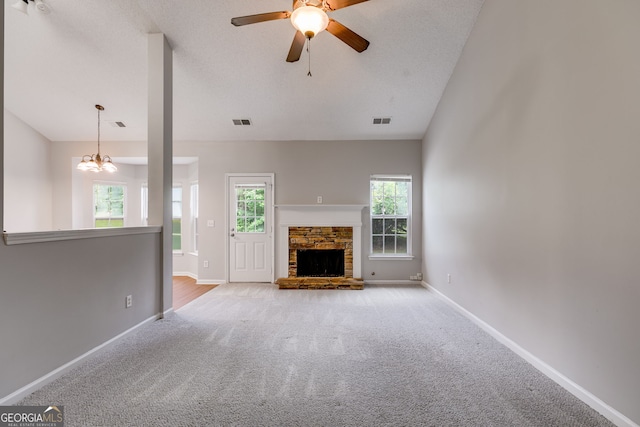 305 Overland Trl, Temple, GA 30179 - unfurnished living room with carpet flooring, ceiling fan, baseboards, a stone fireplace, and a chandelier