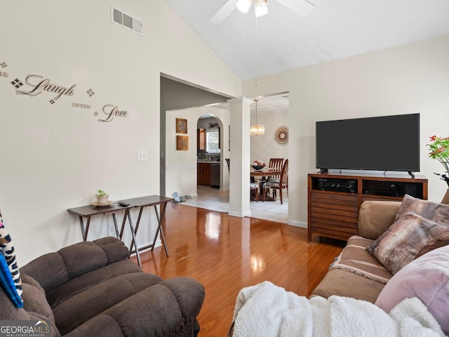 8180 Chapman Ter, Mcdonough, GA 30252 - living area featuring arched walkways, a ceiling fan, wood finished floors, a chandelier, and high vaulted ceiling