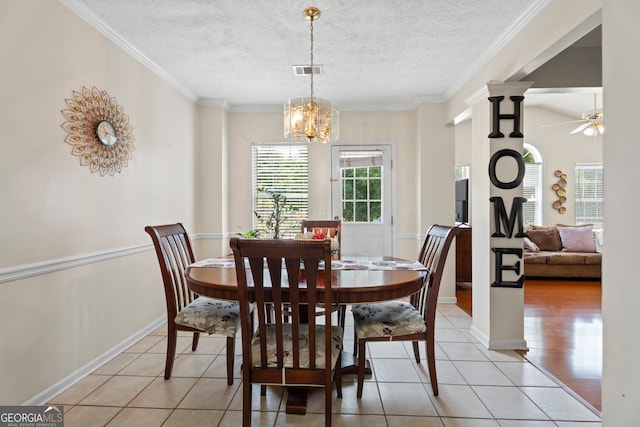 8180 Chapman Ter, Mcdonough, GA 30252 - dining room with light tile patterned flooring, ceiling fan, a chandelier, a textured ceiling, and ornamental molding