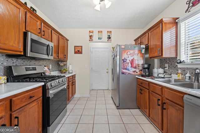 8180 Chapman Ter, Mcdonough, GA 30252 - kitchen featuring appliances with stainless steel finishes, a sink, light tile patterned floors, light countertops, and backsplash